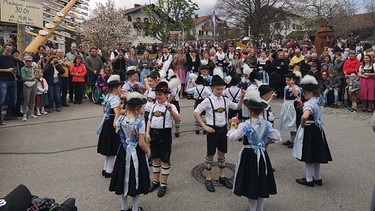 Während der Maibaum in Seebruck aufgestellt wird, tanzt die Kindertrachtengruppe des Trachtenvereins. | Bild: BR, Bewegte Zeiten Filmproduktion GmbH