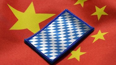 Bayernfahne auf China-Fahne, Wirtschaftsbeziehungen zwischen Bayern und China | Bild: picture-alliance/dpa / Montage BR