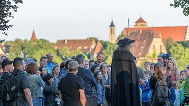 Ein Nachtwächter redet vor Publikum in Rothenburg ob der Tauber.  | Bild: Rothenburg Tourismus Service/Pfitzinger