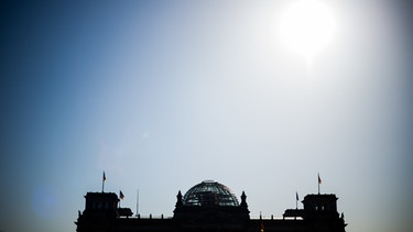 ARCHIV - Die Sonne scheint über dem Reichstag in Berlin.  | Bild: dpa-Bildfunk/Lukas Schulze