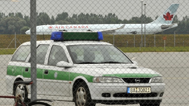 Ein Polizeifahrzeug steht vor einer Maschine der Air Canada mit dem ehemaligen Waffenlobbyisten Karlheinz Schreiber an Bord | Bild: picture-alliance/dpa