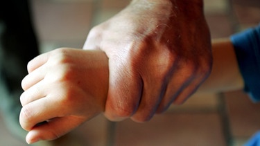 Männerhand umgreift hart das Handgelenk eines Kindes: Symbolfoto für Kindsmissbrauch und Gewalt  | Bild: colourbox.com