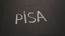 Pisa mit weißer Schulkreide auf schwarzes Papier geschrieben
| Bild: BR/Thomas Schmidt