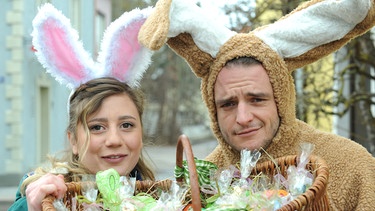 Osterhase Florian verteilt mit Sarah Ostereier an die amüsierten Lansinger. Von links: Sarah Brandl (Sophie Reiml) und Florian Brunner (Tommy Schwimmer). | Bild: BR/Marco Orlando Pichler