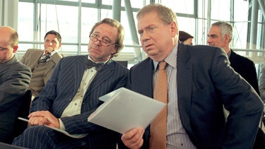 Dr. Sommerfeld (Rainer Hunold, rechts) besucht mit seinem Kollegen Dr. Weber (Gerd Silberbauer) die Veranstaltung eines Pharmakonzerns. | Bild: ARD Degeto/Noreen Flynn