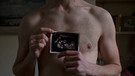 Freddy, schwanger, mit einem Ultraschall-Bild seines Kindes. | Bild: BR/WDR/Danny Burrows