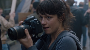 Jelena (Nika Rozman) fotografiert auf der Demo in Hamburg. | Bild: BR/Hamburg Media School