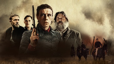 Der australische Bandit Ned Kelly (George MacKay, vorne) kämpft gegen die britische Obrigkeit, verkörpert von Sergeant Kevin O’Neil (Charlie Hunnam, l.) und Constable Alexander Fitzpatrick (Nicholas Hoult, 2. v. l.). | Bild: Punk Spirit Holdings Pty Ltd, Channel Four Television Corporation, Asia Film Investment Group Ltd and Screen Australia 2019