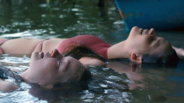 Elisa (Stephanie Amarell, links) und Anthea (Lisa Vicari, rechts) haben es ans andere Ufer des Sees geschafft. | Bild: SWR/Filmakademie