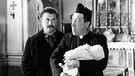 Don Camillo (Fernandel, rechts) weigert sich, das Baby seines Lieblingsfeindes Peppone (Gino Cervi) zu taufen. | Bild: ARD Degeto