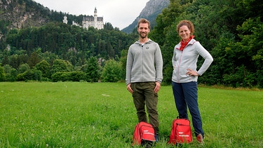 Das Ziel ist erreicht: An Schloss Neuschwanstein treffen sich Anne Willmes und Daniel Aßmann wieder auf ihrer Reise entlang der Deutschen Alpenstraße. | Bild: WDR/Norman Born