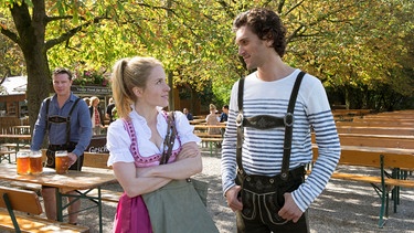 Martin (Florian Panzer, links) beobachtet, wie Jackie (Paula Kalenberg) mit Serge (Vladimir Korneev) flirtet. | Bild: ARD Degeto/Erika Hauri