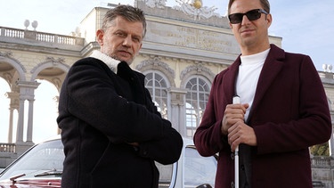 Ex-Kommissar Haller (Philipp Hochmair, rechts) und Niko (Andreas Guenther) vor der Gloriette im Wiener Schlossgarten. | Bild: ARD Degeto/Mona Film/Tivoli Film/Petro Domenigg