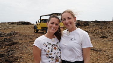 Jeeptour mit den Reiseleiterinnen Lisa und Talina: Gemeinsam mit ihrem Fahrer Willi geht es durch die nicht sehr attraktive Stadt, aber dann an einen Aussichtspunkt, von dem man die steinerne Brücke im Meer sehen kann. Die beiden Reiseleiterinnen sind begeistert von der Landschaft. Talina war schon mal in privat in Aruba und liebt die Gegensätze. | Bild: BR/Bewegte Zeiten Filmproduktion GmbH/Deborah Stöckle