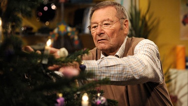 Alois (Erich Hallhuber sen.) übernimmt das Schmücken des Christbaums. | Bild: BR/Marco Orlando Pichler