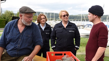 Julia Demmler (Wendy Güntensperger, 2. von links) und Nele Fehrenbach (Floriane Daniel, 2. von rechts) befragen Johannes Roth (Martin Reik, links) und dessen Sohn Michael Roth (Leon Seidel, rechts) erneut, da inzwischen feststeht, dass Greta nie in Australien war. | Bild: ARD/Laurent Trümper