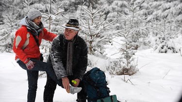 Caro hat sich auf der Wanderung den Fuß verstaucht. Von links: Caro Ertl (Teresa Rizos) und Jürgen Wiesmüller (Michael Schanze). | Bild: BR/Marco Orlando Pichler