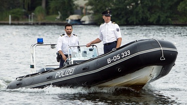 Wolf Malletzke (Christoph Grunert, rechts) und Fahri Celik (Hassan Akkouch, links) mit dem Polizeiboot auf dem Weg zur Ruderstrecke Grünau - die Olympionikin Dagmar Ehwald wurde tot im Wasser gefunden. | Bild: ARD/Daniela Incoronato