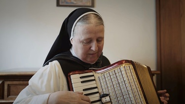 Sr. Teresita spielt auf dem Akkordeon. | Bild: ORF/BR/Tellux-Film GmbH/Metafilm GmbH