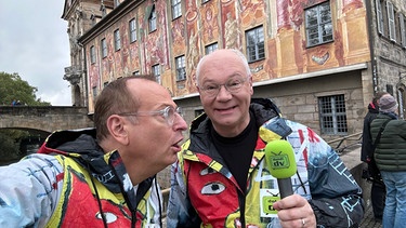 Doldi-TV in Bamberg. Das pfiffige Reporter-Duo Stefan Strohstern (Martin Rassau, rechts) und Theo Dolores Hanfgruber (Volker Heißmann, links) entdecken staunend Bamberg. | Bild: BR/Volker Heißmann