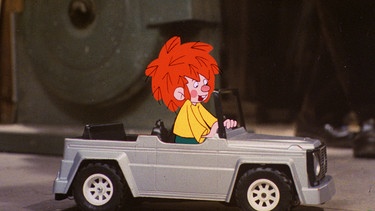 Ein Jahr wohnt nun Pumuckl bei Meister Eder. Zum Jubiläum bekommt er ein Spielzeugauto geschenkt, mit dem er in der Schreinerwerkstatt umherbraust. | Bild: BR/Infafilm GmbH/Original-Entwurf "Pumuckl"-Figur: Barbara von Johnson