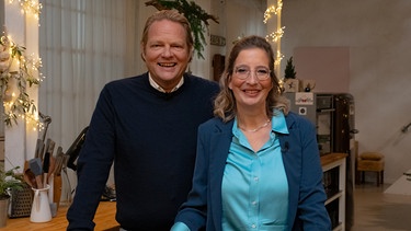 Björn Freitag und Yvonne Willicks bereiten in freudiger Erwartung der Gäste einen Snack vor: Weihnachtskranz aus Schinken, Käse, Oliven, Nüssen und Rosmarinzweigen. | Bild: WDR/2Bild TV.Events & Media GmbH/Simon Frewert