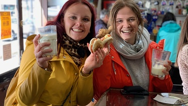 Punta Arenas in Chile. Sous-Chefin Steffi Gehrlein und Küchenpraktikantin Laura Bauer haben Pause und machen einen Stadtausflug. Im Kiosko Roca auf der Plaza de Armas bestellen sie Brötchen und Bananenmilchshakes. | Bild: BR/Bewegte Zeiten Filmproduktion GmbH/Gerrit Mannes