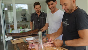 Buenos Aires in Argentinien. Sänger Pablo Grande mit seinem musikalischen Leiter Arno Koch bei einem typischen Asado bei seiner Freundin Silvia. Hier zeigt Pablo Arno wie das Grillen typisch vorbereitet wird. | Bild: BR/Bewegte Zeiten Filmproduktion GmbH/Farah M'haimdat