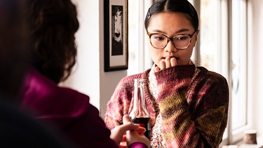 Lien (Nui Nguyen) und Till (Marinus Hohmann) stehen im Kiosk und versuchen, das Geschehene zu klären. | Bild: BR/Lena Semmelroggen