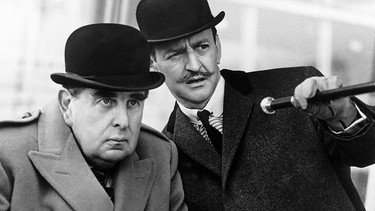 Der belgische Meisterdetektiv Hercule Poirot (Tony Randall, rechts) ist in London einem Serienkiller auf der Spur. Dabei wird er gegen seinen Willen von dem glücklosen britischen Geheimagenten Hastings (Robert Morley) unterstützt. | Bild: WDR/Degeto