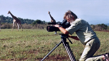 Ulrich Nebelsiek beim Filmen von Rothschildgiraffen. | Bild: © NDR/NDR/Nebelsiek Filmproduktion GmbH, honorarfrei - Verwendung gemäß der AGB im engen inhaltlichen, redaktionellen Zusammenhang mit genannter NDR-Sendung bei Nennung "Bild: NDR/NDR/Nebelsiek Filmproduktion GmbH" (S2). NDR Presse und Information/Fotoredaktion, Tel: 040/4156-2306 oder -2305, pressefoto@ndr.de.