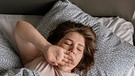 Junge Frau im Bett gähnt | Bild: Picture alliance/dpa