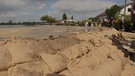 Helfer errichten Behelfsdamm aus Sandsäcken gegen Hochwasser der Zusam | Bild: BR