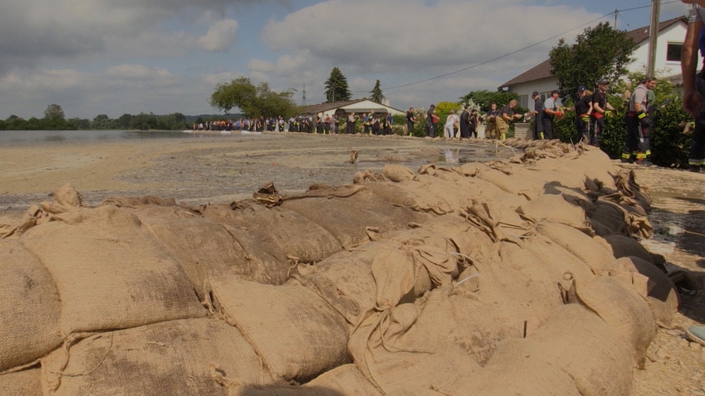 Helfer errichten Behelfsdamm aus Sandsäcken gegen Hochwasser der Zusam | Bild: BR