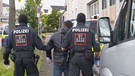 Zwei Polizisten führen Verdächtigen ab | Bild: BR