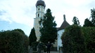 Zwei Männer begrüßen sich vor der Kirche St. Anna in Schondorf | Bild: BR