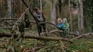 Zwei Kleinkinder spielen mit Betreuerin im Wald | Bild: BR