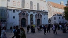 Passanten in der Münchner Fußgängerzone laufen an der Kirche St. Michael vorbei | Bild: BR