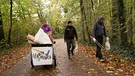 Menschen sammeln Müll in Waldstück | Bild: BR