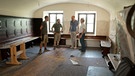 Vier Männer stehen in einer Wirtshausstube, die gerade renoviert wird | Bild: BR