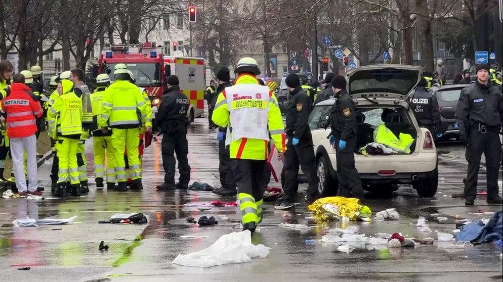 13.02.2025, Bayern, München: Rettungskräfte stehen am Einsatzort. In der Münchner Innenstadt ist ein Fahrzeug in eine Menschengruppe gefahren. Foto: Peter Kneffel/dpa +++ dpa-Bildfunk +++ | Bild: dpa-Bildfunk/Peter Kneffel