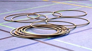 Hula-Hoop-Reifen in einer Sporthalle. | Bild: stock.adobe.com