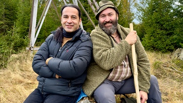 Der prominente Comedian und Musiker Bülent Ceylan (links) besucht seinen Freund Wolfgang Schreil (rechts) im Bayerischen Wald. In der Talk-Show von Hannes Ringlstetter haben sich der Hesse und der Bayer vor einigen Jahren kennen und schätzen gelernt. Die Geschichte einer Spinne, die sich auf Woifes Hut ein Netz gesponnen hatte, sorgte damals für einen legendären Lachanfall. Humor verbindet! | Bild: BR/Wolter media/Ben Wolter