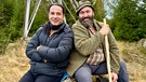 Der prominente Comedian und Musiker Bülent Ceylan (links) besucht seinen Freund Wolfgang Schreil (rechts) im Bayerischen Wald. In der Talk-Show von Hannes Ringlstetter haben sich der Hesse und der Bayer vor einigen Jahren kennen und schätzen gelernt. Die Geschichte einer Spinne, die sich auf Woifes Hut ein Netz gesponnen hatte, sorgte damals für einen legendären Lachanfall. Humor verbindet! | Bild: BR/Wolter media/Ben Wolter