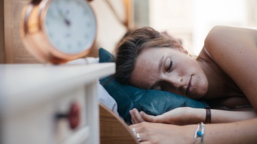 Eine Frau liegt im Bett und schläft. | Bild: BR/Julia Müller