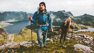 Ein Mann und eine Frau wandern in den Bergen. | Bild: stock.adobe.com/EVERST