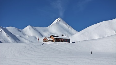 Verschneite Berghütte im Schweizer Hochgebirge | Bild: BR/Josef Bayer