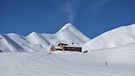 Verschneite Berghütte im Schweizer Hochgebirge | Bild: BR/Josef Bayer