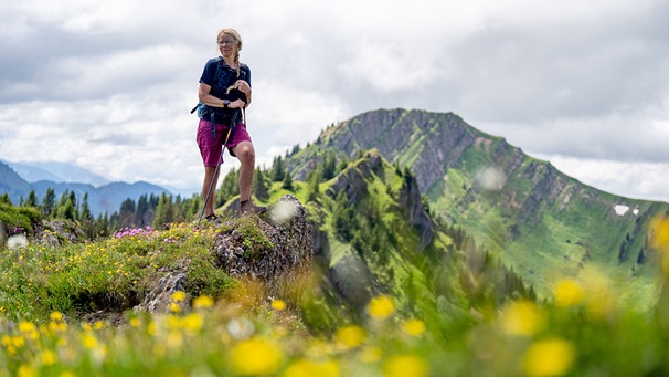 Alix von Melle steht auf dem mit Blumen bewachsenen Bärenköpfle | Bild: BR/Thomas März