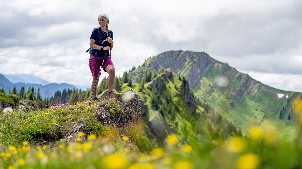 Alix von Melle steht auf dem mit Blumen bewachsenen Bärenköpfle | Bild: BR/Thomas März